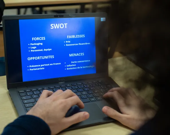 Un étudiant faisant un SWOT sur son ordinateur  